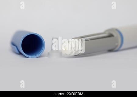 Medicina, diabete e medicina. Macro penna autoiniezione su sfondo bianco Foto Stock