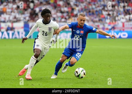 L'inglese Kobbie Mainoo (a sinistra) e la slovacca Stanislav Lobotka si battono per il pallone durante la partita UEFA Euro 2024, round of 16 all'Arena AufSchalke di Gelsenkirchen, in Germania. Data foto: Domenica 30 giugno 2024. Foto Stock