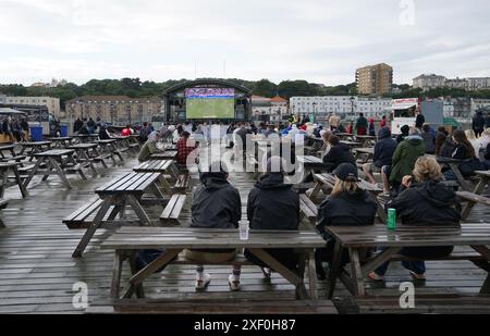 Tifosi inglesi sull'Hastings Pier nell'East Sussex, durante una proiezione della partita UEFA Euro 2024, round of 16, tra Inghilterra e Slovacchia. Data foto: Domenica 30 giugno 2024. Foto Stock