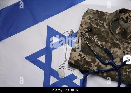 Stetoscopio, cartelli e uniforme militare sulla bandiera di Israele, piatto Foto Stock