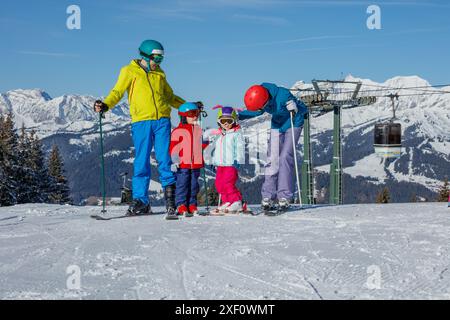 La famiglia è felice, la funivia e le vette di montagna sullo sfondo Foto Stock