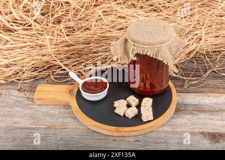 Marmellata di rosehip fatta in casa in una ciotola di vetro con frutta di rosa fresca su fondo rustico ( rosa canina ). Deliziosa rosehip biologica, marmellata rosa hip Foto Stock