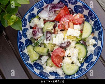 Insalata greca tradizionale con pomodori maturi, cetrioli croccanti, saporite olive nere Kalamata, formaggio feta cremoso, condito con olio d'oliva Foto Stock