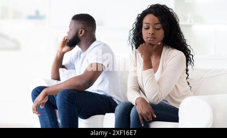 Coppia seduta separatamente sul divano Foto Stock