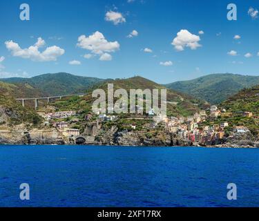 Bella estate Manarola vista dalla nave di escursione. Uno di cinque famosi villaggi del Parco Nazionale delle Cinque Terre in Liguria, Italia, sospeso tra Lig Foto Stock