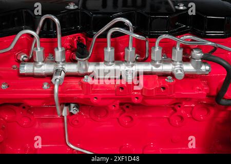Un motore rosso con un tubo flessibile argento che fuoriesce. Il tubo flessibile è collegato a un tubo nero Foto Stock
