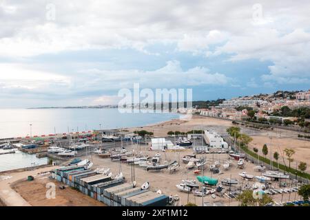 Vista aerea della spiaggia con barche, che mostra un bellissimo paesaggio con nuvole sparse nel cielo e design urbano lungo l'orizzonte Foto Stock