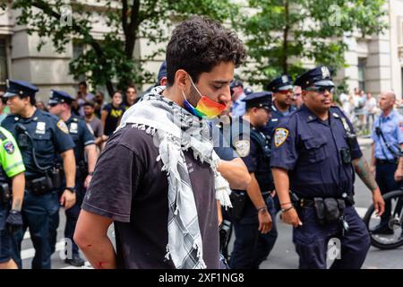 New York, New York, Stati Uniti. 30 giugno 2024. I manifestanti pro-palestinesi trattengono la Pride March di New York su Christopher Street, a un isolato dallo storico Stonewall Inn, si rifiutano di muoversi, e alla fine vengono arrestati pacificamente e portati via dalla polizia. Un manifestante e' portato via in manette. Crediti: Ed Lefkowicz/Alamy Live News Foto Stock