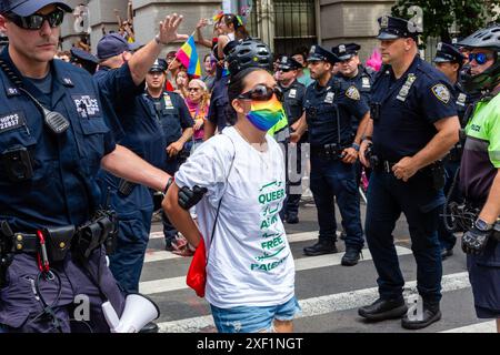 New York, New York, Stati Uniti. 30 giugno 2024. I manifestanti pro-palestinesi trattengono la Pride March di New York su Christopher Street, a un isolato dallo storico Stonewall Inn, si rifiutano di muoversi, e alla fine vengono arrestati pacificamente e portati via dalla polizia. Un manifestante e' portato via in manette. Crediti: Ed Lefkowicz/Alamy Live News Foto Stock