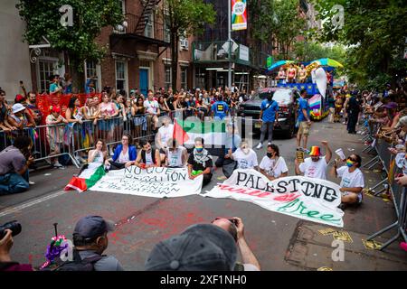 New York, New York, Stati Uniti. 30 giugno 2024. I manifestanti pro-palestinesi trattengono la Pride March di New York su Christopher Street, a un isolato dallo storico Stonewall Inn, si rifiutano di muoversi, e alla fine vengono arrestati pacificamente e portati via dalla polizia. Crediti: Ed Lefkowicz/Alamy Live News Foto Stock