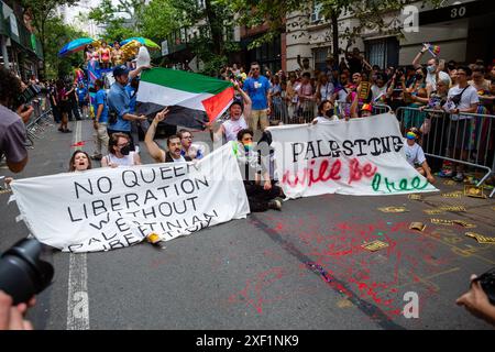 New York, New York, Stati Uniti. 30 giugno 2024. I manifestanti pro-palestinesi trattengono la Pride March di New York su Christopher Street, a un isolato dallo storico Stonewall Inn, si rifiutano di muoversi, e alla fine vengono arrestati pacificamente e portati via dalla polizia. Crediti: Ed Lefkowicz/Alamy Live News Foto Stock