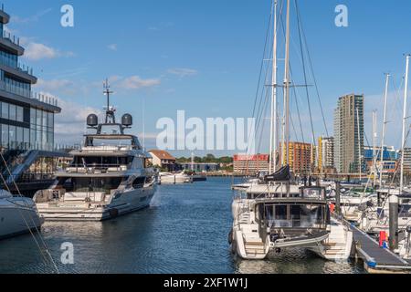 Vista del villaggio sull'oceano verso la Vantage Tower, un alto edificio residenziale con yacht ormeggiati in primo piano durante l'estate, Southampton, Regno Unito, Inghilterra Foto Stock