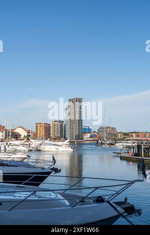 Vista del villaggio sull'oceano verso la Vantage Tower, un alto edificio residenziale con yacht ormeggiati in primo piano durante l'estate, Southampton, Regno Unito, Inghilterra Foto Stock