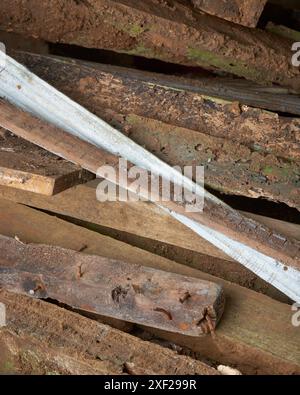 pile di vecchie tavole di legno di scarto provenienti da cantieri o cantieri di demolizione, pila di legno di spazzatura con schegge di chiodi, primo piano di fondo di immondizia Foto Stock