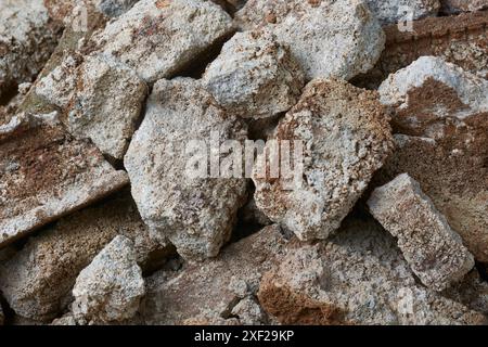 demolizione di pezzi di cemento o macerie, cumuli di lacerazioni o rottura di strutture o pareti in cemento, frammenti di rovina o rocce in primo piano Foto Stock