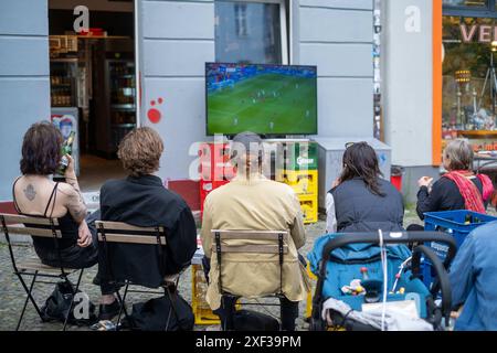 VOR einem Späti in der Oderberger Straße in Berlin-Prenzlauer Berg verfolgen Fußballfans das Spiel Türkei gegen Portugal anlässlich des Fußballeuropameisterschaft UEFA EURO 2024. / I tifosi di calcio guardano la partita tra Turchia e Portogallo davanti a un negozio notturno su Oderberger Straße a Berlino-Prenzlauer Berg durante il Campionato europeo di calcio UEFA EURO 2024. UEFA Fußball-Europameisterschaft - Fußballfans *** i tifosi di calcio guardano la partita tra Turchia e Portogallo di fronte a un negozio notturno su Oderberger Straße a Berlino Prenzlauer Berg durante il Campionato europeo di calcio U Foto Stock