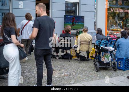 VOR einem Späti in der Oderberger Straße in Berlin-Prenzlauer Berg verfolgen Fußballfans das Spiel Türkei gegen Portugal anlässlich des Fußballeuropameisterschaft UEFA EURO 2024. / I tifosi di calcio guardano la partita tra Turchia e Portogallo davanti a un negozio notturno su Oderberger Straße a Berlino-Prenzlauer Berg durante il Campionato europeo di calcio UEFA EURO 2024. UEFA Fußball-Europameisterschaft - Fußballfans *** i tifosi di calcio guardano la partita tra Turchia e Portogallo di fronte a un negozio notturno su Oderberger Straße a Berlino Prenzlauer Berg durante il Campionato europeo di calcio U Foto Stock