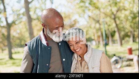 Coppia innamorata, felice e senior nel parco per passeggiate, esercizio fisico e fitness in pensione nella natura o nella foresta. Partner, diversificato e supporto o fiducia per l'uomo Foto Stock
