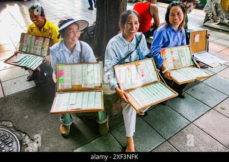 Thailandia, Bangkok. Donne che vendono biglietti della lotteria sul marciapiede. Foto Stock