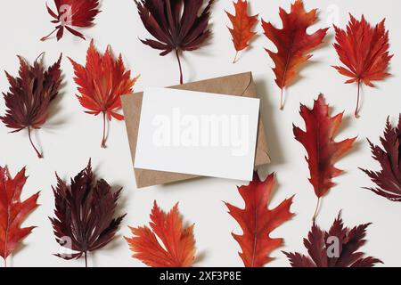 Composizione floreale autunnale. Foglie di rovere cremisi e acero colorate di colore rosso, isolate su sfondo bianco. Biglietto d'auguri vuoto, modello di invito. Halloween, Foto Stock