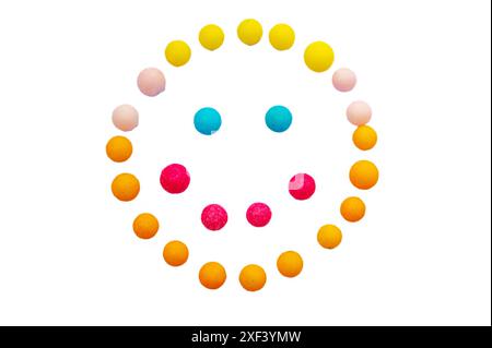 Faccia sorridente realizzata con caramelle colorate su sfondo bianco. Dessert per bambini, happy food. Foto Stock
