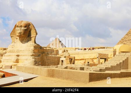 La grande Sfinge di Giza con piramidi e cammelli. Giza, il Cairo, l'Egitto Foto Stock