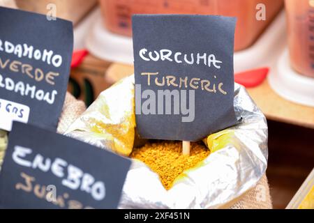 Polvere di spezie di curcuma sfuse fresche in vendita in un mercato spagnolo delle spezie. La curcuma viene venduta in peso da una grande borsa aperta. Foto Stock