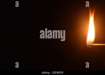 il fiammifero rosso si accende e si accende su sfondo scuro Foto Stock