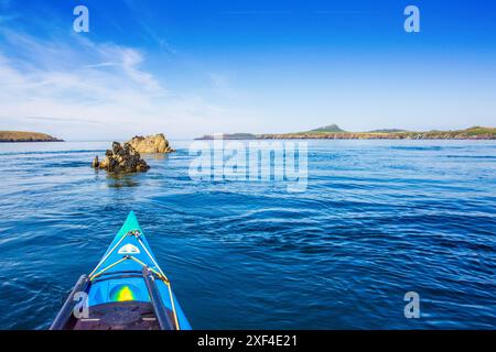 Kayak in mare verso St Davids dirigersi al largo della costa del Pembrokeshire nel Galles occidentale Foto Stock