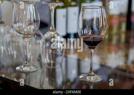 diversi bicchieri di vino su un tavolo di vetro in una cantina durante una degustazione di vini. Messa a fuoco selettiva Foto Stock