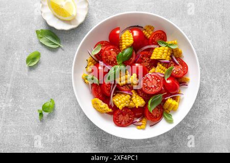 Insalata di pomodoro e mais con basilico fresco, cipolla, condita con olio d'oliva. Cibo messicano, insalata di pomodoro e mais, vista dall'alto Foto Stock