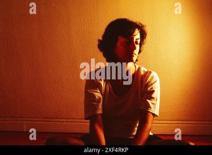 Giovane donna sola in una stanza. Foto Stock