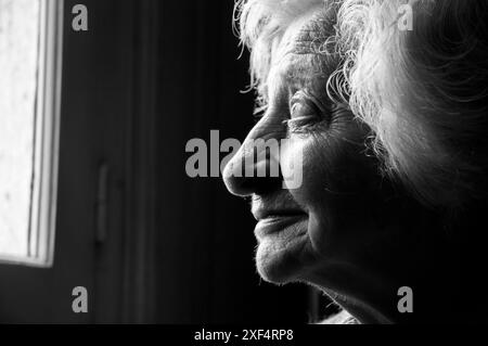 Profilo ritratto di una donna anziana sorridente. Bianco e nero. Foto Stock