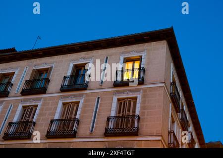 Finestra illuminata sulla facciata della casa, vista notturna. Piazza Isabella II, Madrid, Spagna. Foto Stock