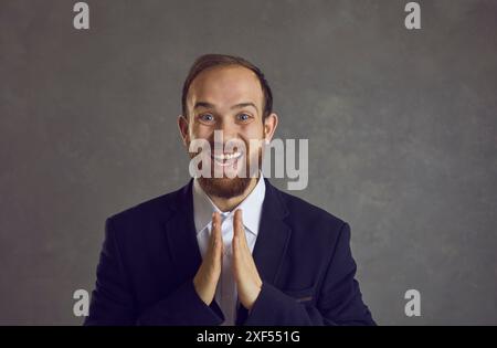 Ritratto della testa di Studio di un giovane uomo d'affari felice e bello che batte le mani Foto Stock