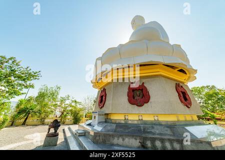 Vista dal basso della gigantesca statua bianca del Buddha sullo sfondo blu del cielo presso la Pagoda di hai Duc a Nha Trang, provincia di Khanh Hoa in Vietnam. Foto Stock