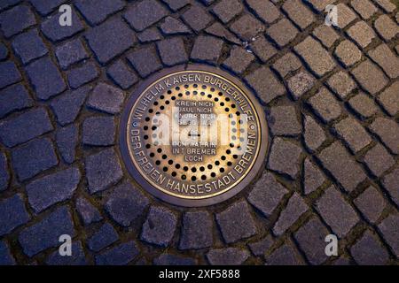 Bremer Loch sulla piazza del mercato di Brema è un'installazione interattiva di donazioni del 2007. Si tratta di un tombino di bronzo con una fessura per monete che riproduce le voci animali dei musicisti della città di Brema - gallo, gatto, cane e asino - quando vengono inserite le monete. I proventi vanno a beneficio di progetti sociali a Brema ogni anno. Bremer Loch sulla piazza del mercato. Il foro di Brema funge da cassetta di denaro per la Wilhelm Kaisen Bürgerhilfe della libera città anseatica di Brema. Dopo aver inserito una moneta, si può sentire il tipico richiamo di un musicista di Brema. Asino, cane, gatto o gallo. Brema, Germania Foto Stock