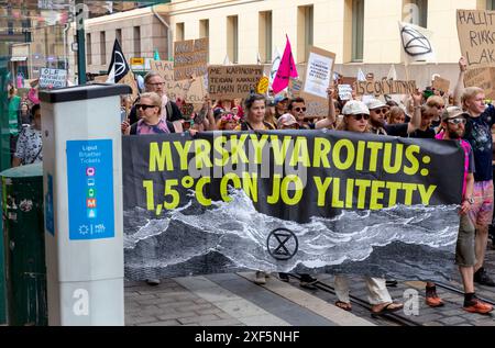 Protesta di «Storm warning» detenuta da Extinction Rebellion Finland passando per una fermata del tram ad Aleksanterinkatu, nel centro di Helsinki, il 30 giugno 2024. Foto Stock