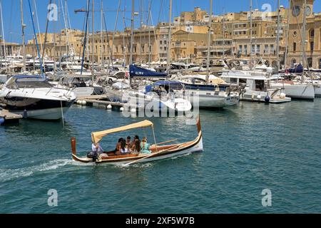 La Valletta, Malta - 3 agosto 2023: Piccolo taxi d'acqua che porta i passeggeri attraverso il porto turistico nella zona delle tre città di la Valletta Foto Stock