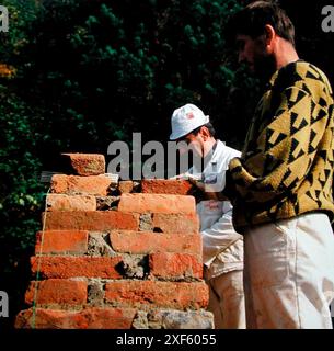 mason costruisce un muro di mattoni, lavori di costruzione su un cantiere edile mason costruisce un muro di mattoni Foto Stock