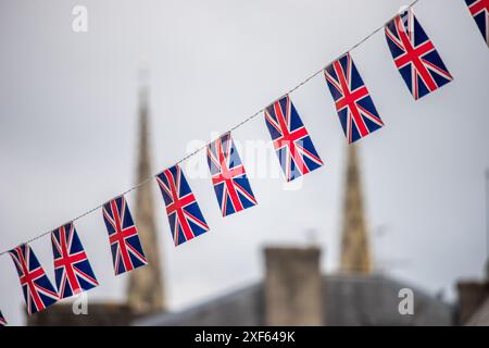 Bandiere Union Jack visualizzate su una corda con una vista sfocata di Quimper, Bretagna, Francia sullo sfondo. Foto Stock