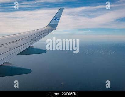 Vista dalla finestra dell'aeroplano KLM sul Mare del Nord con turbine eoliche in lontananza, Europa Foto Stock