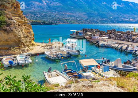 Cefalonia, Grecia, 28 giugno 2024. Piccole barche da pesca nel porto di Pessada, Cefalonia, isole greche con acque cristalline e fondali montuosi Foto Stock