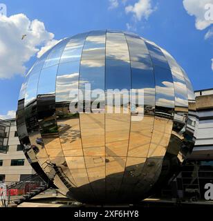 La Millennium Sphere riflette il cielo blu e le nuvole soffici nel Millennium Square, nel centro di Bristol. Foto Stock