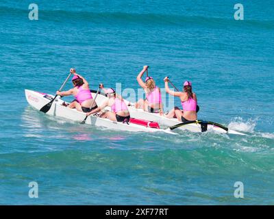 Tauranga nuova Zelanda - gennaio 28 2012; donne surf canoa Paddlers che si dirigono all'evento di surf club al Mount Maunganui Surf Lifesaving Competition. Foto Stock