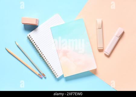 Notebook, matite, penne in feltro e cucitrice su sfondo a colori Foto Stock