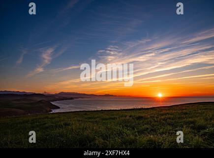 Una vista panoramica di un bellissimo tramonto su un paesaggio costiero Foto Stock