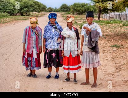 Basarwa quattro donne africane che camminano su strade sterrate, gente di San, villaggio nel Kalahari Foto Stock