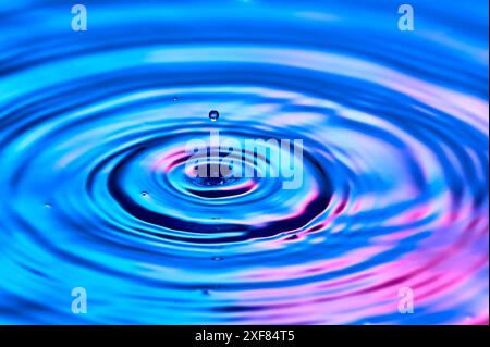 una goccia d'acqua che cade nell'acqua e crea onde Foto Stock