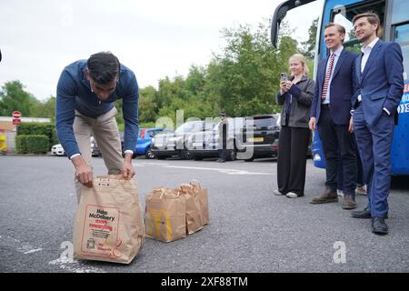 Il primo ministro Rishi Sunak raccoglie le colazioni di McDonald presso i servizi di Beaconsfield nel Buckinghamshire per dare ai media di viaggio, mentre si trova sulle tracce della campagna elettorale generale. Data foto: Martedì 2 luglio 2024. Foto Stock